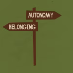 A sign shows a fork in the road between autonomy and belonging
